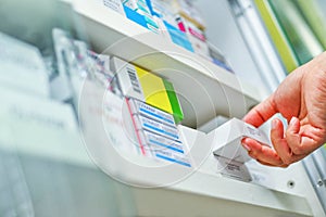 Pharmacist hand holding medicine box in pharmacy