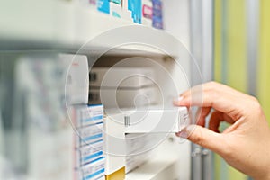 Pharmacist hand holding medicine box in pharmacy