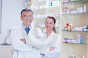 Pharmacist with his trainee standing with arms crossed