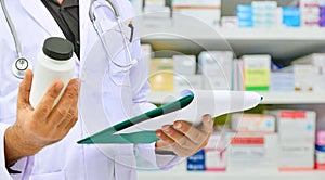 Pharmacist holding medicine bottle in pharmacy