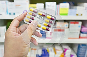 Pharmacist holding medicine capsule pack at the pharmacy drugstore