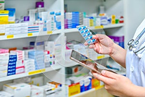 Pharmacist holding mobile phone using for filling prescription