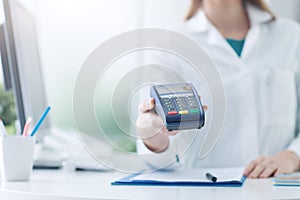 Pharmacist holding a payment terminal