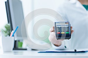 Pharmacist holding a payment terminal