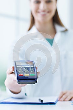 Pharmacist holding a payment terminal