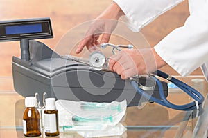 Pharmacist or medical doctor using cash register