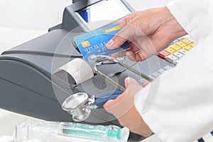 Pharmacist or medical doctor using cash register