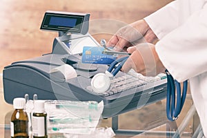 Pharmacist or medical doctor using cash register