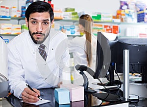 Pharmacist near computer in pharmacy