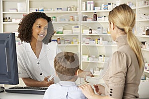 Pharmacist in pharmacy with mother and child