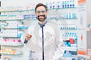 Pharmacist in pharmacy selling pharmaceuticals in bag