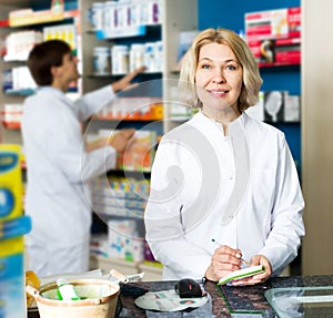 Pharmacist and pharmacy technician posing in drugstore