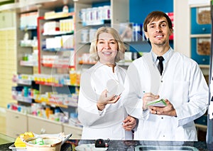 Pharmacist and pharmacy technician posing in drugstore