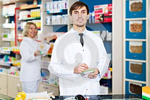 Pharmacist and pharmacy technician posing in drugstore