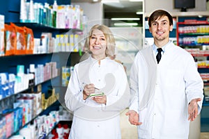 Pharmacist and pharmacy technician posing in drugstore