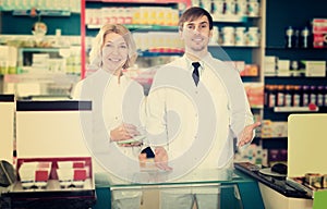 Pharmacist and pharmacy technician posing in drugstore