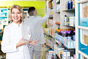 Pharmacist and pharmacy technician posing in drugstore