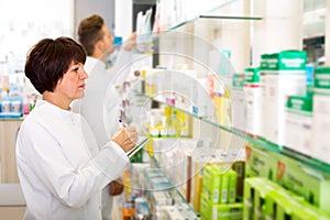 Pharmacist and pharmacy technician posing in drugstore