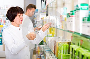 Pharmacist and pharmacy technician posing in drugstore