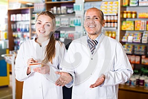 Pharmacist and pharmacy technician posing in modern farmacy