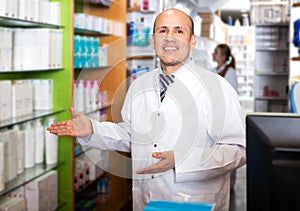 Pharmacist and pharmacy technician posing in modern farmacy photo