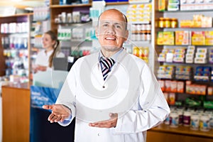 Pharmacist and pharmacy technician posing in modern farmacy photo