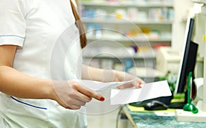 Pharmacist with prescriptions in front of medicines at drugstore