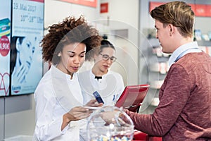 pharmacist selling prescribed medicines to a customer in a moder