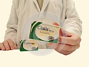 Pharmacist showing a box of Cialis