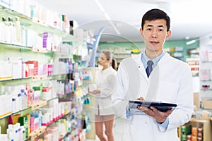 Pharmacist stocktaking medicines in drugstore
