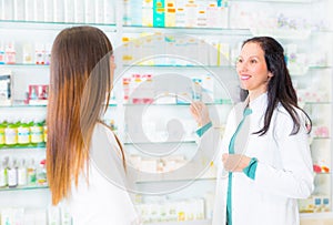 Pharmacist suggesting medical drug to buyer in pharmacy