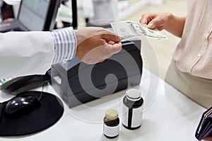 Pharmacist taking money from customer at pharmacy