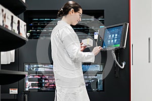 pharmacist using a computer while managing the drug stock in pha