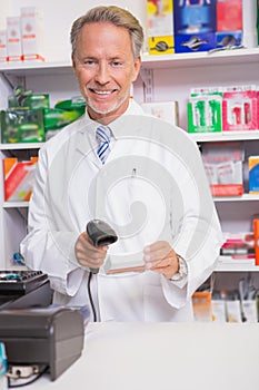 Pharmacist using machine and holding medicine