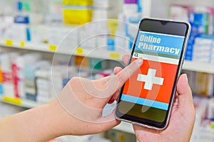 Pharmacist using mobile smart phone in pharmacy