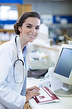 Pharmacist working on computer in pharmacy