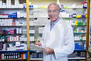 Pharmacist writing on clipboard in pharmacy