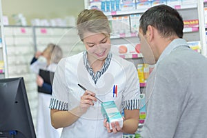 Pharmacist writing dosage on box photo