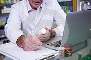 Pharmacist writing prescriptions for medicines photo