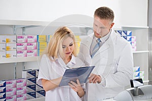 Pharmacists Maintaining Checklist In Pharmacy photo