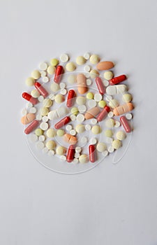 Pharmacology assorted medicine pills, tablets and capsules round frame. Different colors tablet on white background. Top