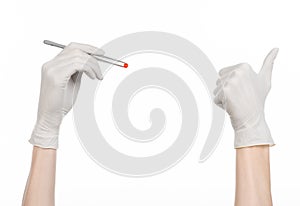 Pharmacology and Medical theme: doctor's hand in a white glove holding tweezers with red pill capsule isolated on white background