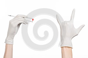 Pharmacology and Medical theme: doctor's hand in a white glove holding tweezers with red pill capsule isolated on white background