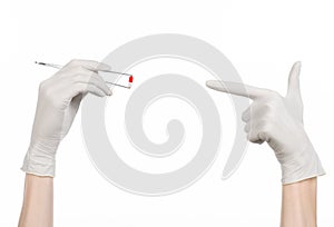 Pharmacology and Medical theme: doctor's hand in a white glove holding tweezers with red pill capsule isolated on white background