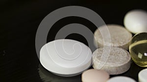 Pharmacy background on a dark table. Levitation pills. Tablets on a dark background which falling down. Pills. Medicine