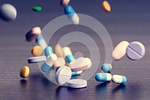 Pharmacy background on a dark table. Levitation pills. Tablets on a dark background which falling down. Pills. Medicine and health photo
