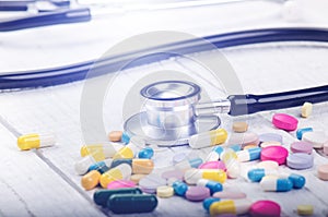 Pharmacy background on a white table. Stethoscope on a white wooden background. Copy space for a text. Tablets on a white backgrou