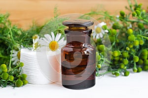 Pharmacy bottle with cosmetic/cleansing/healing wild chamomile aroma oil or tincture and cotton pads for natural skin care