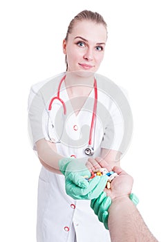 Pharmacy concept with beautiful doctor offering tablets to a pat