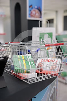 Pharmacy counter desk was cluttered with store shopping basket filled with boxes and packages